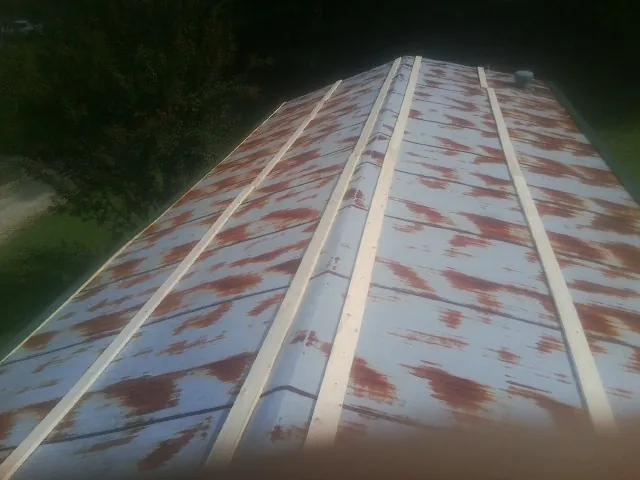 Rusted metal roof panels with new wood purlins before replacement — Storm Damage Roof Repair in Pelahatchie by Roofing Brothers